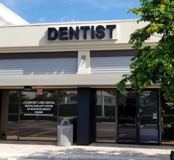The image shows a storefront with the sign  Dentist  prominently displayed above a glass door.